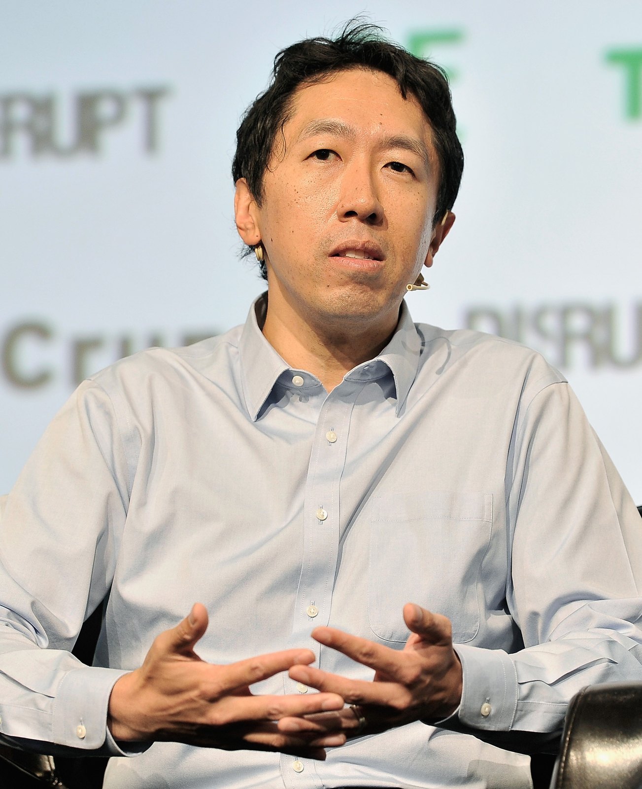 吳恩達在2017年TechCrunch Disrupt SF活動發言,穿淺色襯衫並使用耳掛麥克風;此為歷史照片,非2026年Stanford座談現場。